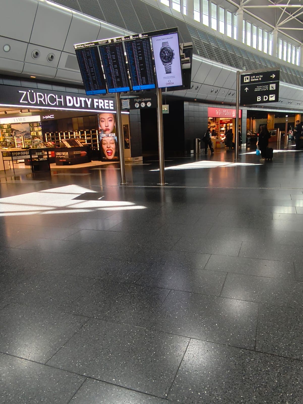 Departure boards above the Zürich Duty Free store at Zurich Airport